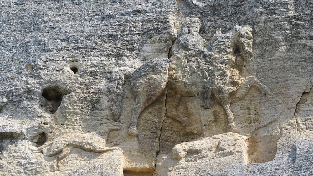 Обр. Мадарският конник, скален релеф край с. Мадара, Шуменско – по него най-ясно личат седлото с висока задна облегалка, покривката, юздата и стремето. Снимка: Octopus, Wikimedia Commons, CC BY-SA 3.0.